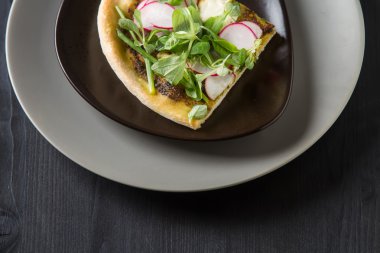 Pesto, marul ve turp gri plaka üzerinde ev İtalyan pizza.