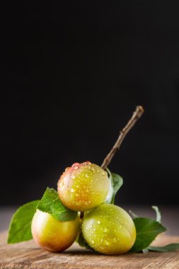 Olgun Erik kırmızı ve sarı. Koyu ahşap arka plan