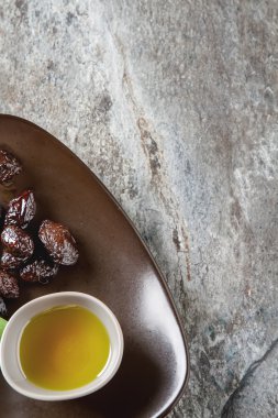 Yeşil Konfit zeytin ve zeytin yağı bir kapta. Koyu arka plan.