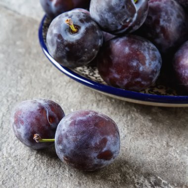 Olgun Erik gri bir ahşap arka plan üzerinde dağınık. Biyo sağlıklı fr