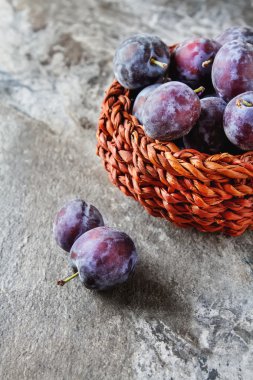 Olgun Erik gri bir ahşap arka plan üzerinde dağınık. Biyo sağlıklı fr