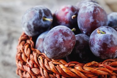 Olgun Erik gri bir ahşap arka plan üzerinde dağınık. Biyo sağlıklı fr