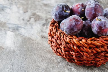 Olgun Erik gri bir ahşap arka plan üzerinde dağınık. Biyo sağlıklı fr