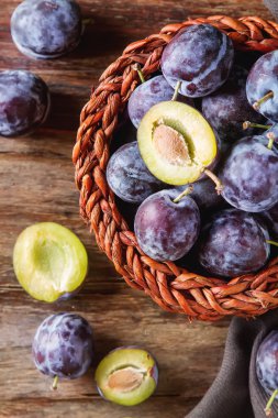 Olgun Erik kahverengi ahşap zemin üzerinde dağınık. Biyo sağlıklı f