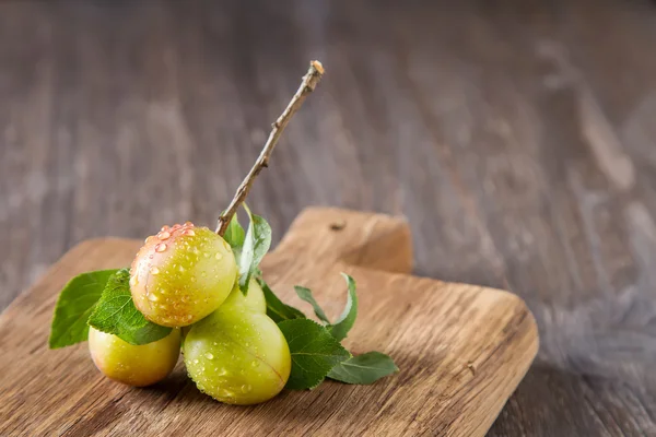 Olgun Erik kırmızı ve sarı. Koyu ahşap arka plan