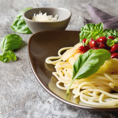 İtalyan mutfağı. Kahverengi bir tabakta parmesan peyniri ile spagetti
