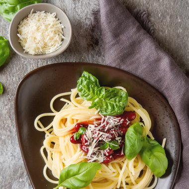 İtalyan mutfağı. Kahverengi bir tabakta parmesan peyniri ile spagetti