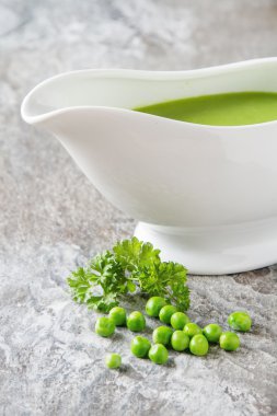 Bezelye çorbası püresi beyaz bir tureen içinde. Taş kayrak arka plan