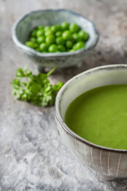 Maydanoz dekorasyonu ile eski bir tabak içinde püre bezelye çorbası. Taş sl