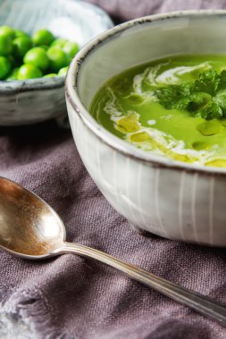 Maydanoz dekorasyonu ile eski bir tabak içinde püre bezelye çorbası. Taş sl