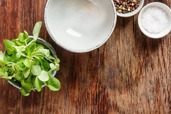 Ensalada verde fresca con sal y pimienta. Fondo de madera oscura. Para —  Fotos de Stock