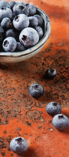 Ripe blueberries in blue old vintage Japanese dish. Red stone ba — Stock Photo, Image