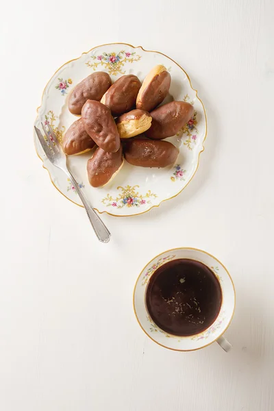 Bolo de chocolate francês, eclairs com uma xícara de café preto quente em — Fotografia de Stock