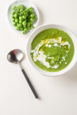 Maydanoz dekorasyonu ile eski bir beyaz kapta püre bezelye çorbası. WHI