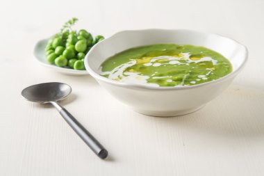 Maydanoz dekorasyonu ile eski bir beyaz kapta püre bezelye çorbası. WHI