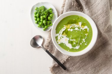 Maydanoz dekorasyonu ile eski bir beyaz kapta püre bezelye çorbası. WHI