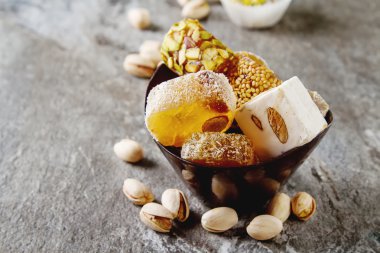 Doğu tatlılar. Bir vazoda Antep fıstığı ile Türk lokumu. Karanlık 