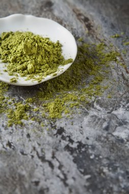 Küçük beyaz tabakta Matcha çay. Gri arka plan. Üstten Görünüm