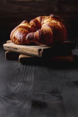 Fransız yemekleri kahvaltı için. Taze pişmiş kruvasanlar. Koyu ahşap bac