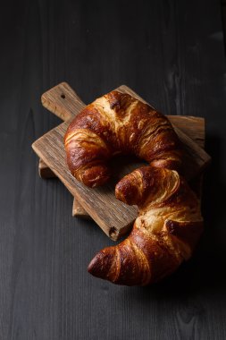 Fransız yemekleri kahvaltı için. Taze pişmiş kruvasanlar. Koyu ahşap bac