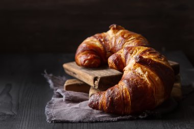 Fransız yemekleri kahvaltı için. Taze pişmiş kruvasanlar. Koyu ahşap bac