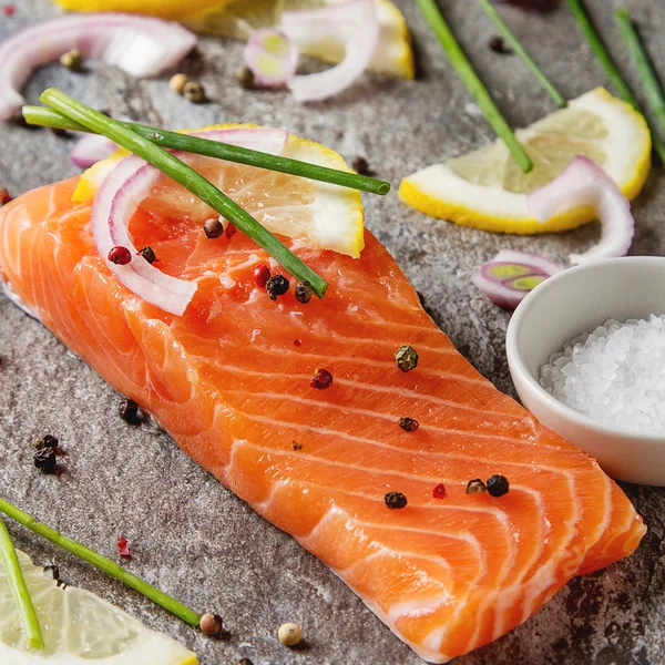 One piece of fresh salmon with lemon pepper and salt. Grey stone