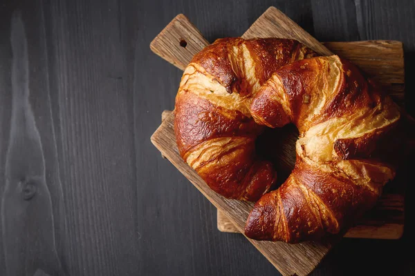 French food for breakfast. Fresh baked croissants. Dark wood bac