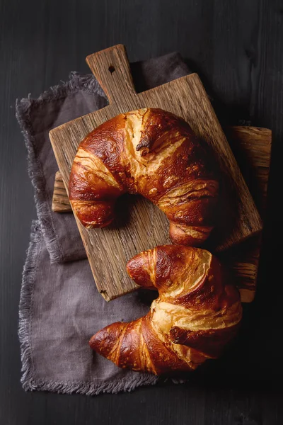 French food for breakfast. Fresh baked croissants. Dark wood bac