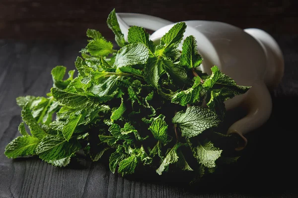 Sprig di menta nel giardino teiera vintage. Fondo in legno scuro — Foto Stock