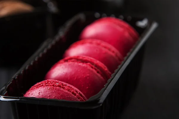 French dessert. Macarons with cocoa, strawberry and lemon in a b