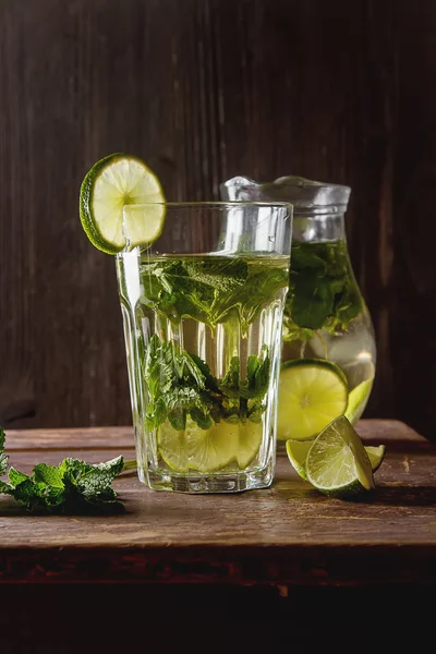 Té helado de menta con lima en el vaso. Fondo oscuro . —  Fotos de Stock