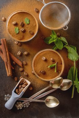 Geleneksel İtalyan mutfağı. Tatlı çikolatalı tiramisu, nane. Kahve çekirdekleri. Siyah ahşap arka plan.