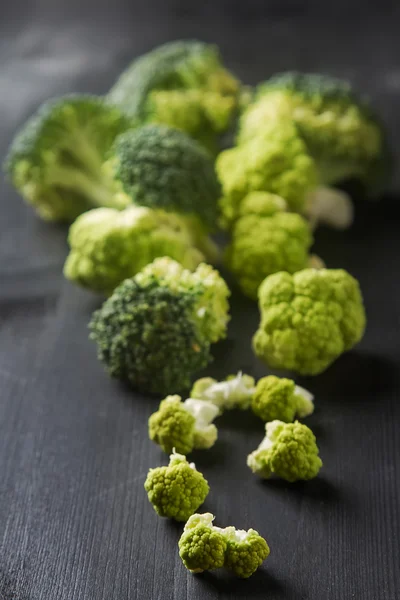 Ripe green cauliflower and broccoli. Dark wood background.