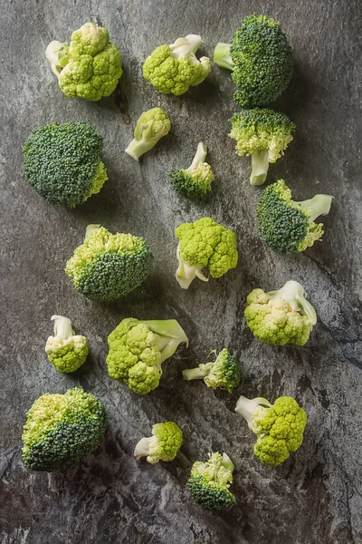 Ripe green broccoli and cauliflower. Grey stone background. Top