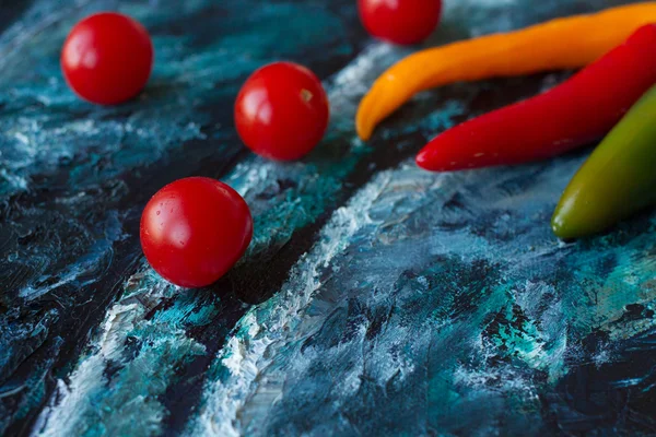 Rote Chilischoten auf blauer Leinwand. Kunst Stillleben — Stockfoto