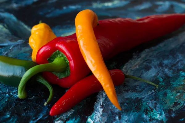 Rote Chilischoten auf blauer Leinwand. Kunst Stillleben — Stockfoto