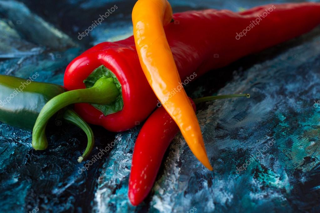Red hot chili peppers on blue canvas. Art Still Life