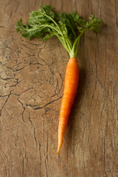 Herkullisia orgaanisia porkkanoita ruskealla taustalla — kuvapankkivalokuva