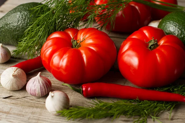 Tomato with avocado and garlic with dill. on wood background — Stock Image Tomato with avocado and garlic with dill. on wood background Stock Picture