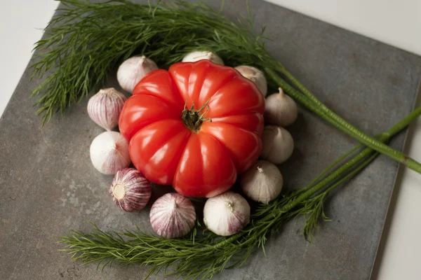 Tomato with avocado and garlic with dill. on wood background — Stock Image Tomato with avocado and garlic with dill. on wood background Stock Image