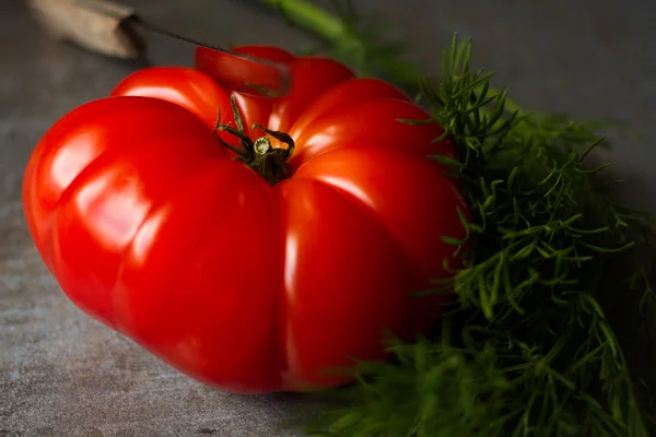 Tomato with avocado and garlic with dill. on wood background — Stock Image Tomato with avocado and garlic with dill. on wood background Stock Photo