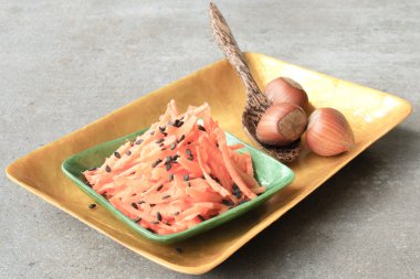 Bir kaşık ve fındık ile gri bir arka plan üzerinde havuç salatası