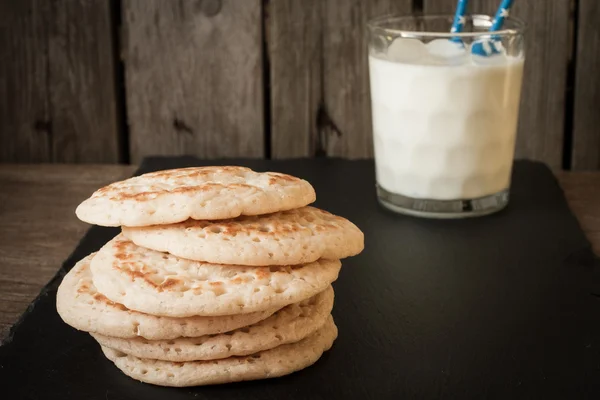 Tortitas con leche sobre un fondo gris — Foto de Stock