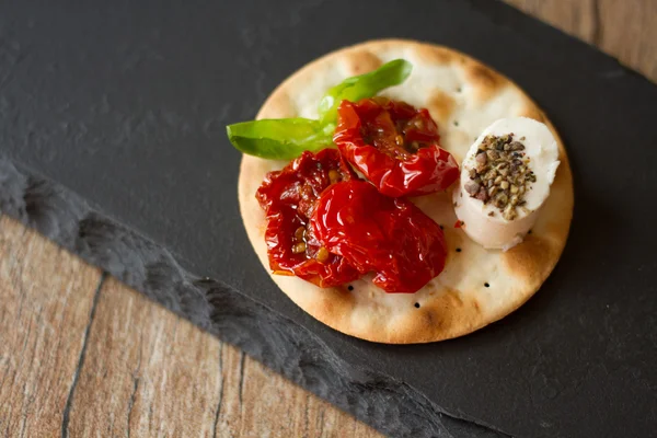 Craquelins au fromage de chèvre, tomates séchées au soleil et basilic — Photo