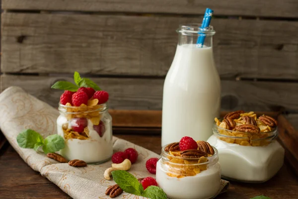 Joghurt zum Frühstück mit Nüssen, Himbeeren und Milch. — Stockfoto