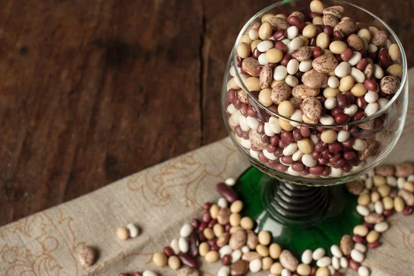 Beans and peas in a green glass — Stock Photo, Image