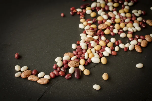 Kacang dan kacang polong di atas batu hitam — Stok Foto