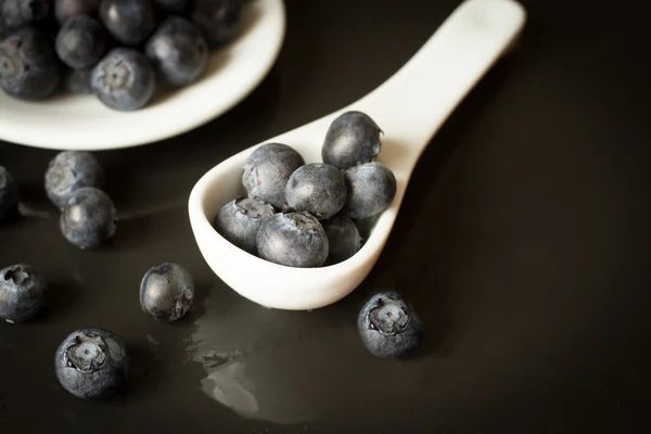 Blueberries with white ceramic spoon — Stock Photo, Image