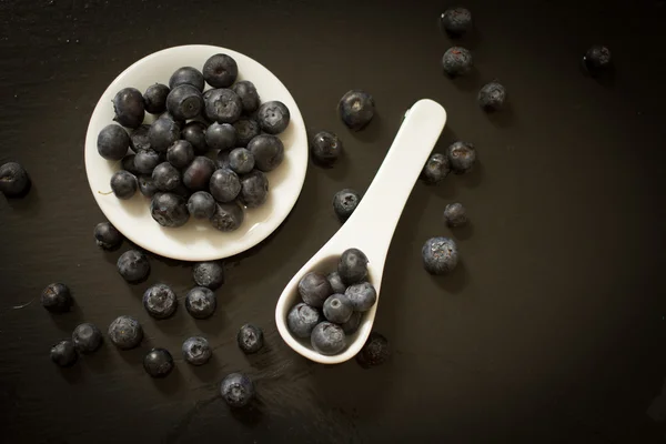 Blaubeeren mit weißem Keramiklöffel — Stockfoto