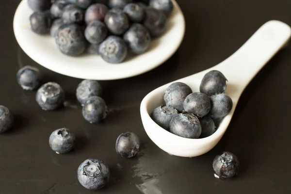 Blueberries with white ceramic spoon — Stock Photo, Image